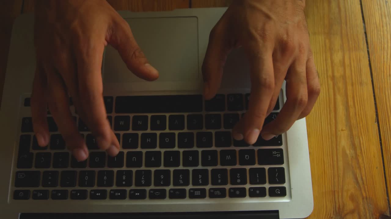 vista de alto ángulo de un hombre de raza mixta usando una computadora portátil en un café 4k