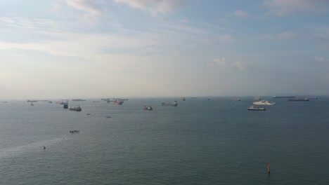 aerial drone shot of container ships and tankers off singapore's coast