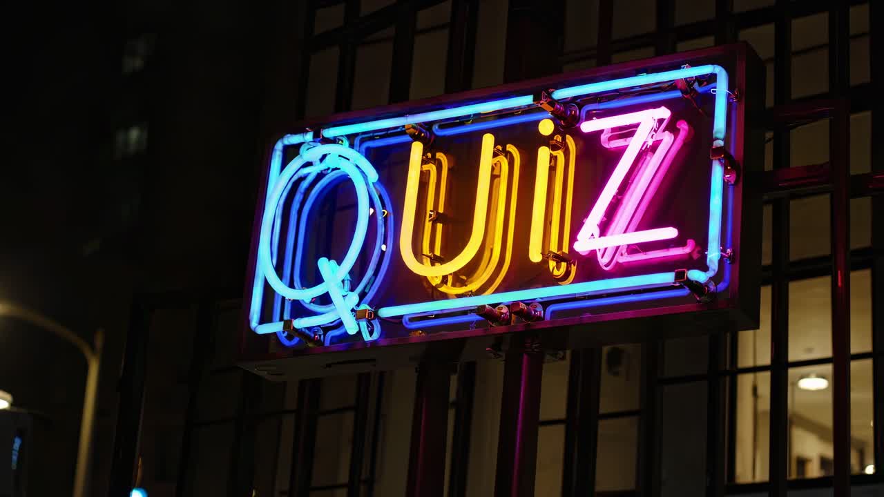 생생한 네온 즈 표지판은 어두운 배경에서 밝게 빛나고, 활기찬 전기 색으로 야간 생활 엔터테인먼트를 강조하며 재미있는 지식 도전을 신호합니다.