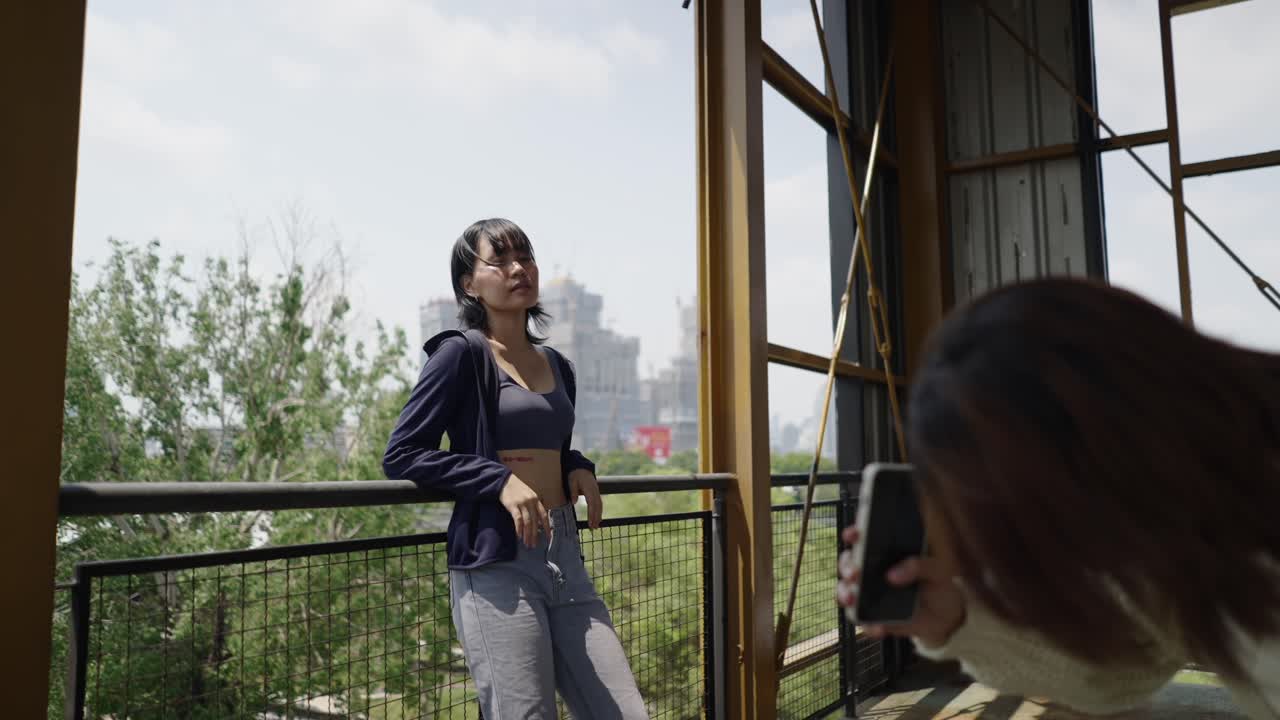 Friends taking photos and posing on a city balcony