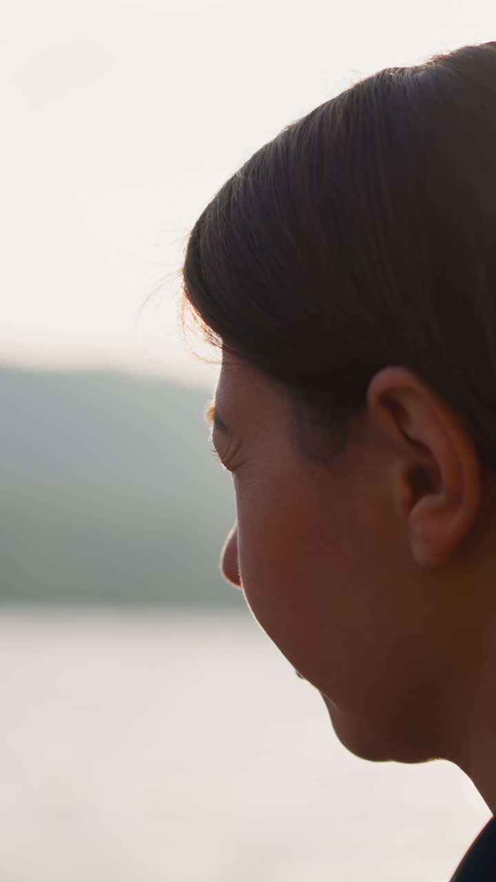 la dama piensa sentada cerca del río al atardecer de cerca. la dama parece molesta pensando en relaciones pasadas rodeada de paisajes montañosos. concepto de soledad