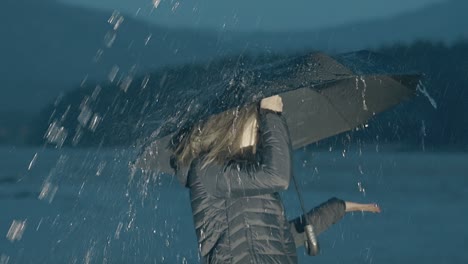 emotional woman with umbrella stands under rain in evening