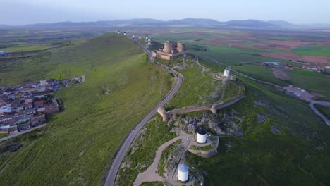 aerial top view of ancient windmills and medieval fortress hill top above consuegra town, spain