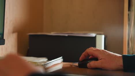 Office-worker-uses-mouse-working-on-computer-at-desk