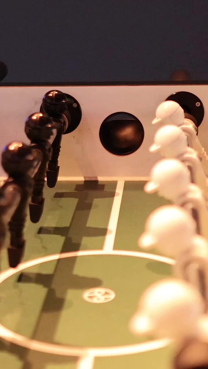 Partita intensa di calcio balilla con squadre bianche e nere