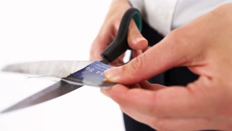 manos de una mujer de negocios cortando una tarjeta de crédito con unas tijeras