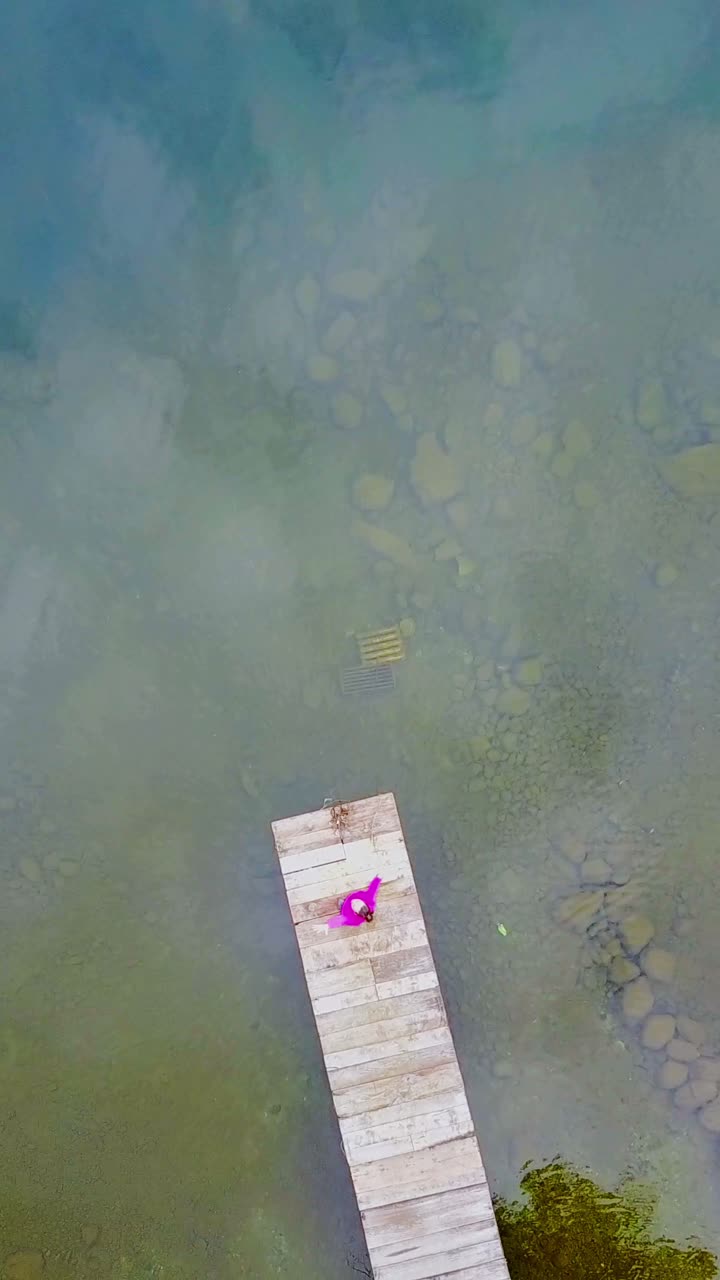 Donna su un pontile di legno sull'acqua