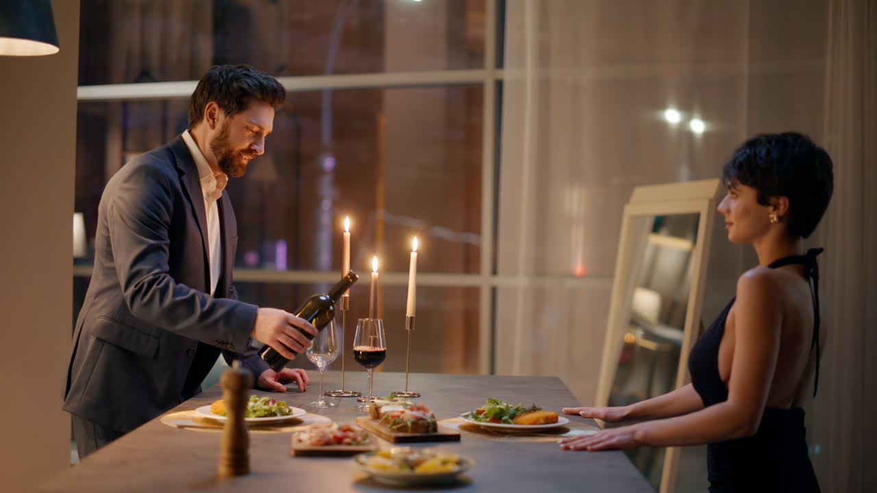 Loving duo getting ready celebration hotel closeup. Cheerful man pouring wine