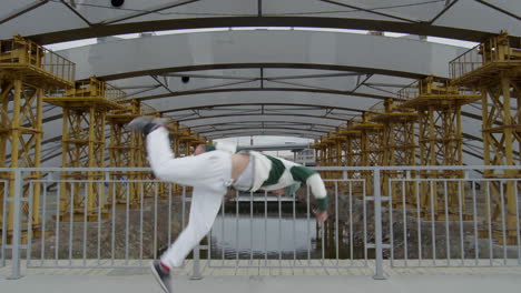parkour athlete doing side flip at urban construction site