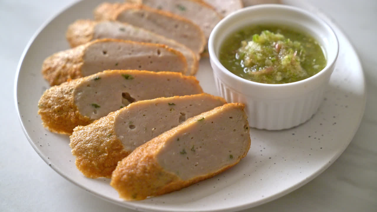 жареный китайский рыбный пирог или рыбный шар, нарезанный ломтиками, с острым соусом из морепродуктов