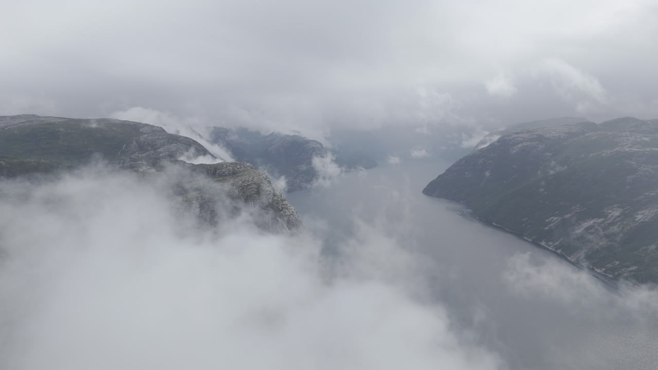 천천히 움직이는 드론 촬영은 노르웨이에서 구름을 통해 날아서 바다와 바다를 드러니다.