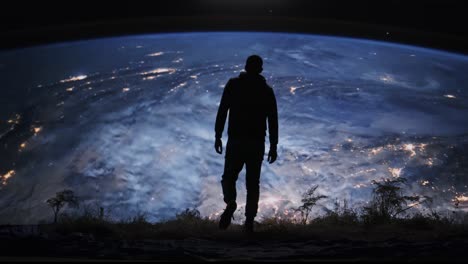 man standing on hilltop gazing at earth from space