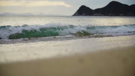 beach in mountainous green paradise with rippling waves