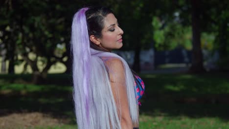 amazing young woman close up at the park with a pretty smile and white hair