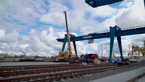 port construction site with heavy cranes and railroad tracks