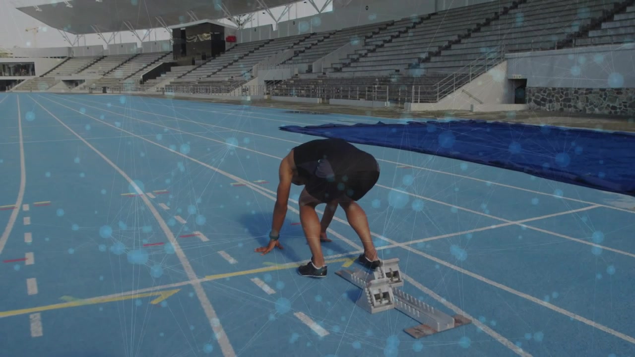 Male athlete walking to blocks, settling feet, placing hands, preparing sprint on blue track