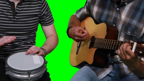mid section of male musicians playing guitar and drum