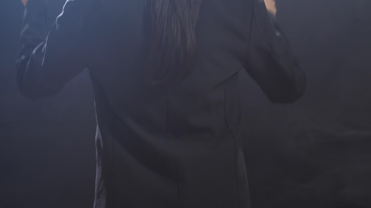 cerca de la vista trasera conductor sosteniendo un bastón y moviéndose en el estudio negro