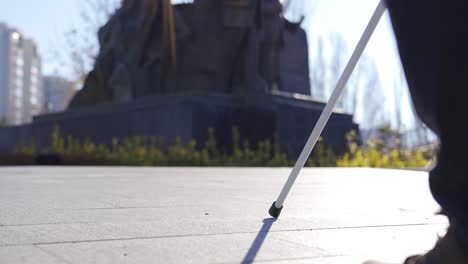 The-visually-impaired-man-is-walking.-Close-up-shot-of-his-walking-stick-and-feet.