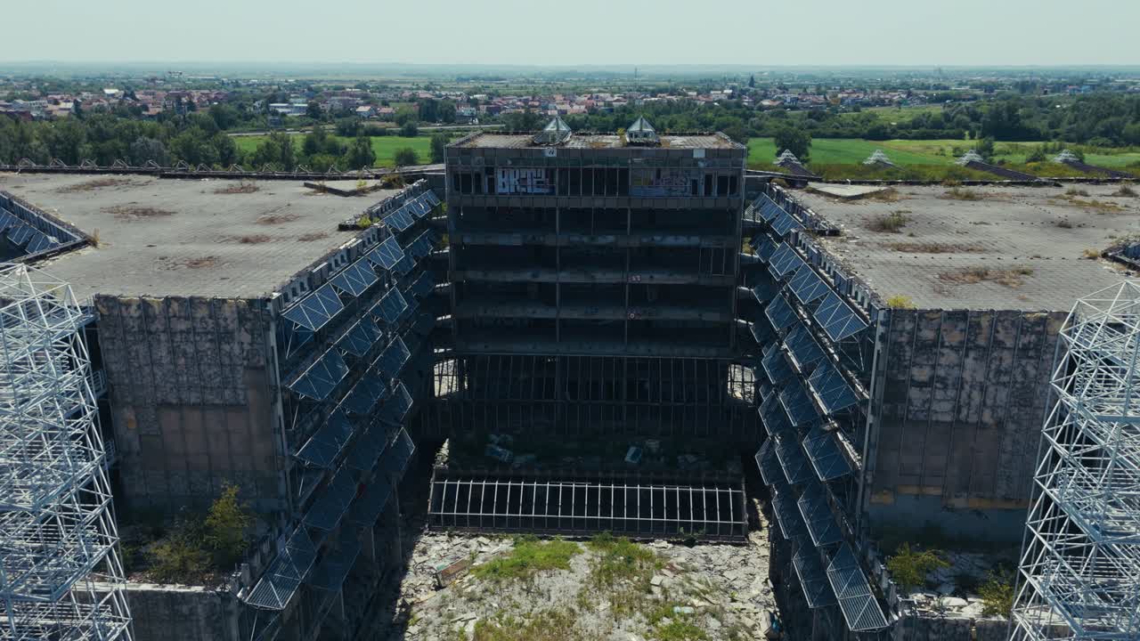 abandoned hospital in Zagreb with crumbling facade and exposed steel structures under clear sky