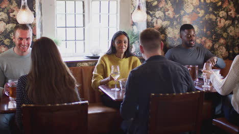 grupo de personas comiendo en un restaurante de un concurrido pub inglés tradicional