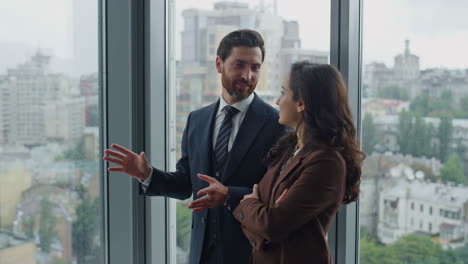 Manager-showing-office-colleague-close-up.-Worker-talking-with-woman-coworker.