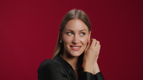 woman putting on earrings