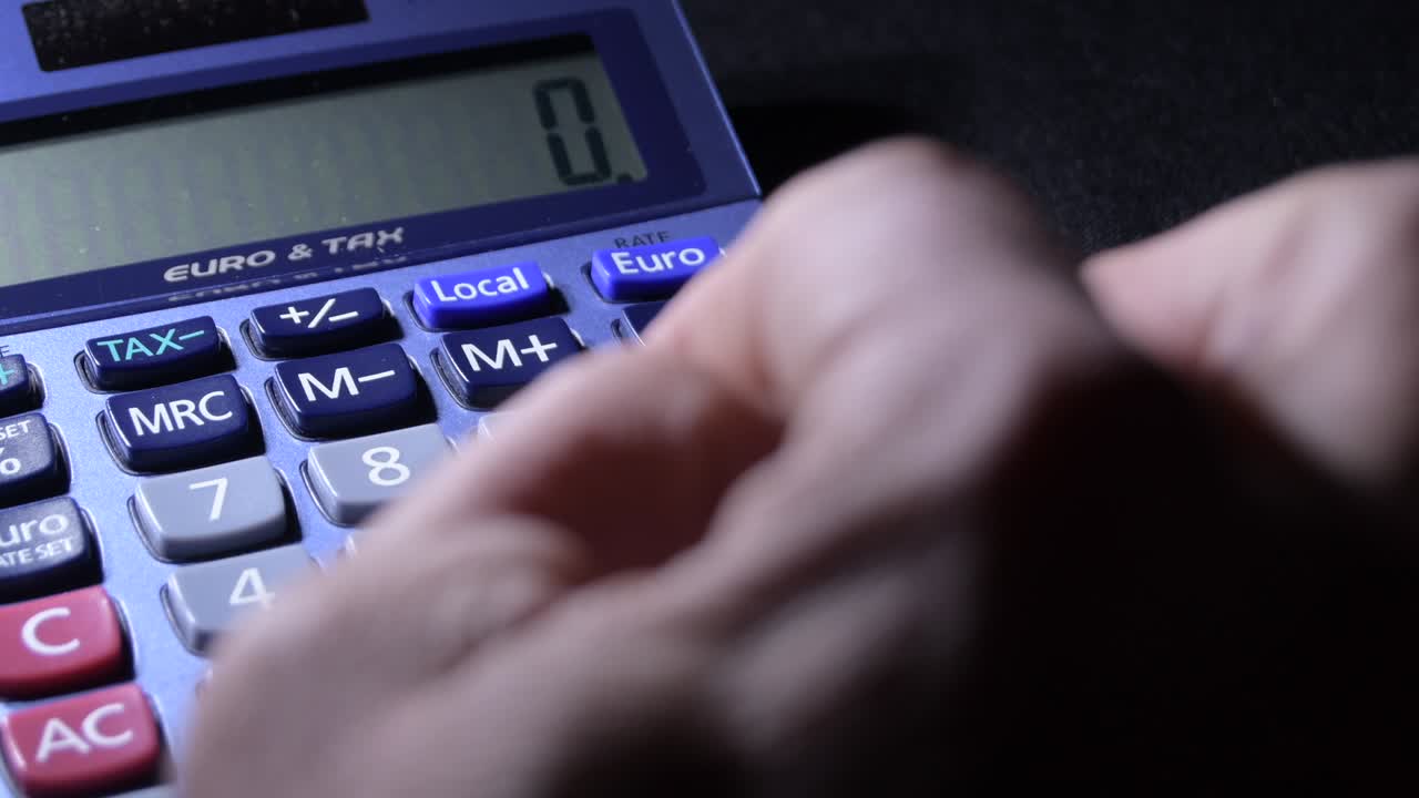 Male finger calculating with a calculator differentes operations