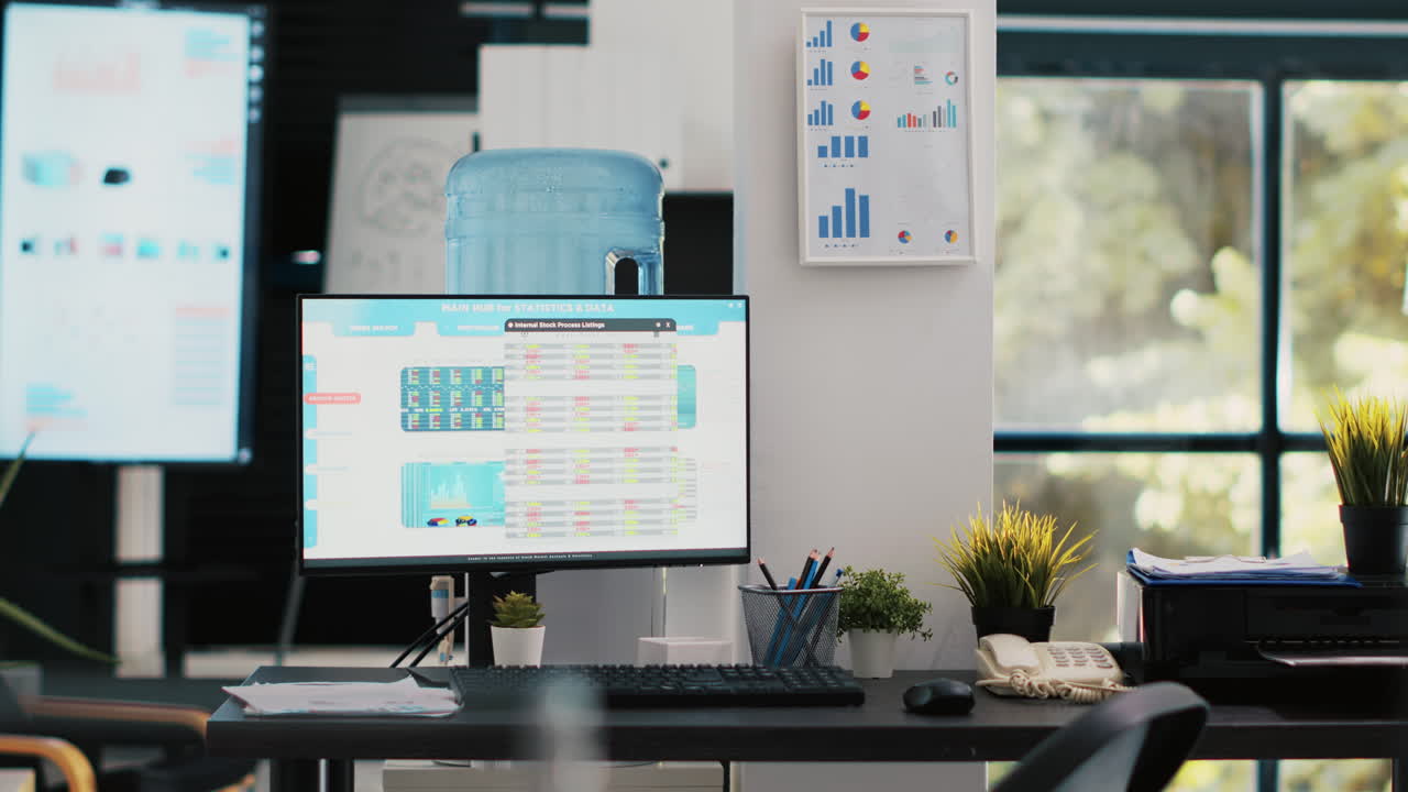 Company workspace with nobody in and business figures on computer monitors