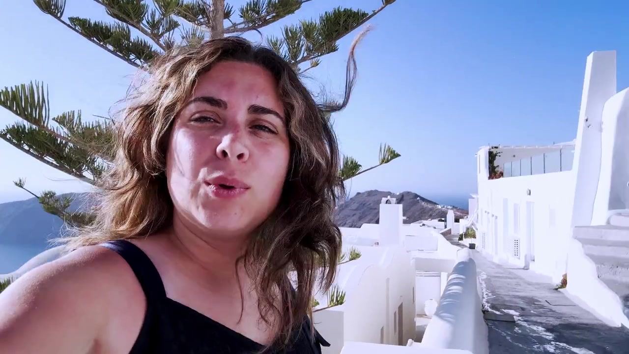 Young influencer vlogging during summer vacation in santorini