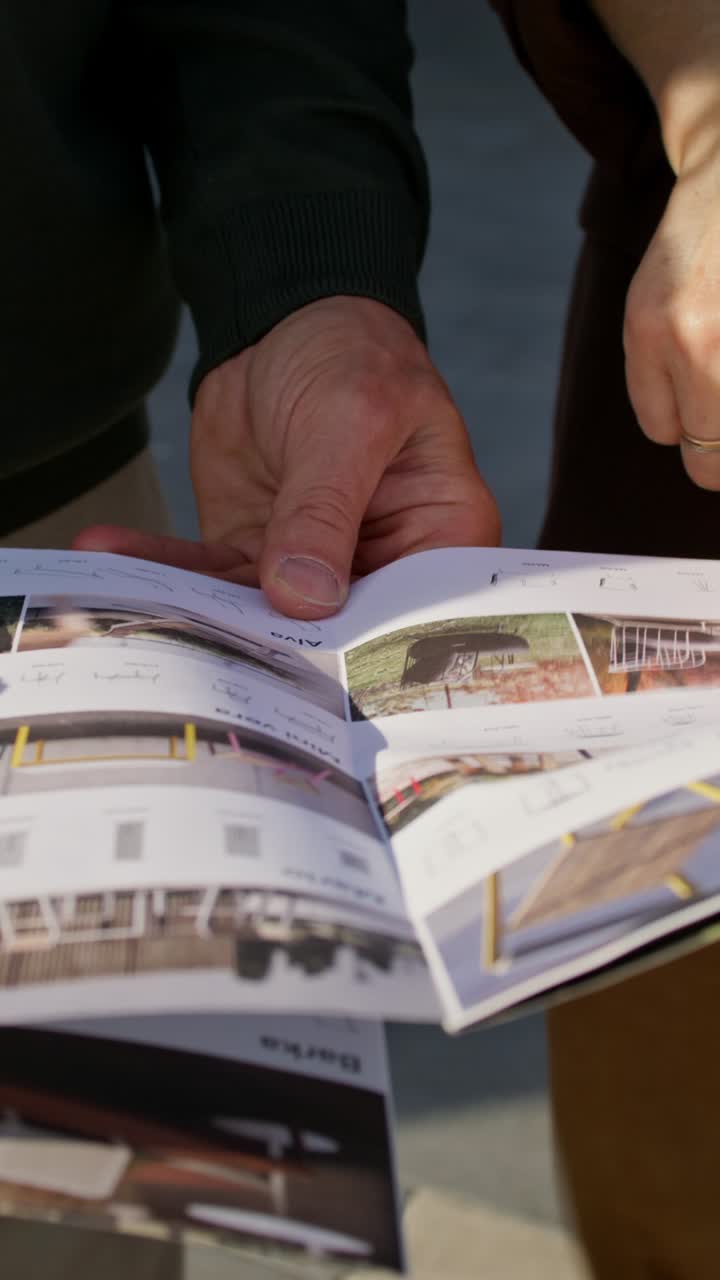 People reviewing a catalog of outdoor furniture designs