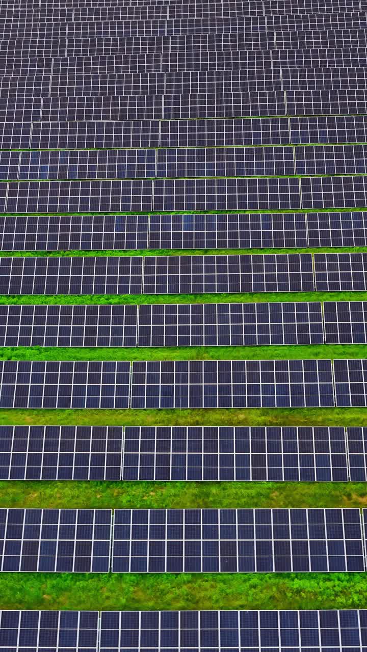 Vertical of vibrant green field intersected by solar panels, blending nature and energy use, aerial backdrop background