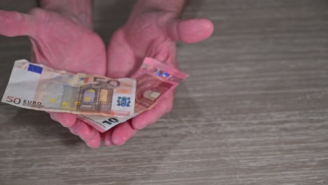 old pensioner hands catch euros falling into his hands