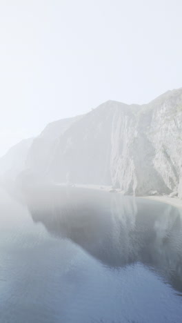 a misty coastal landscape with cliffs