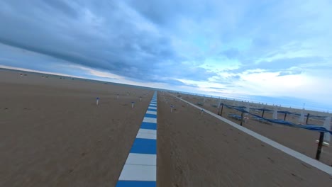 sendero de azulejos blancos y azules que conduce al mar a través de la playa en rimini, italia