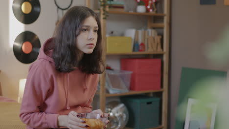 teenage girl snacking in bedroom