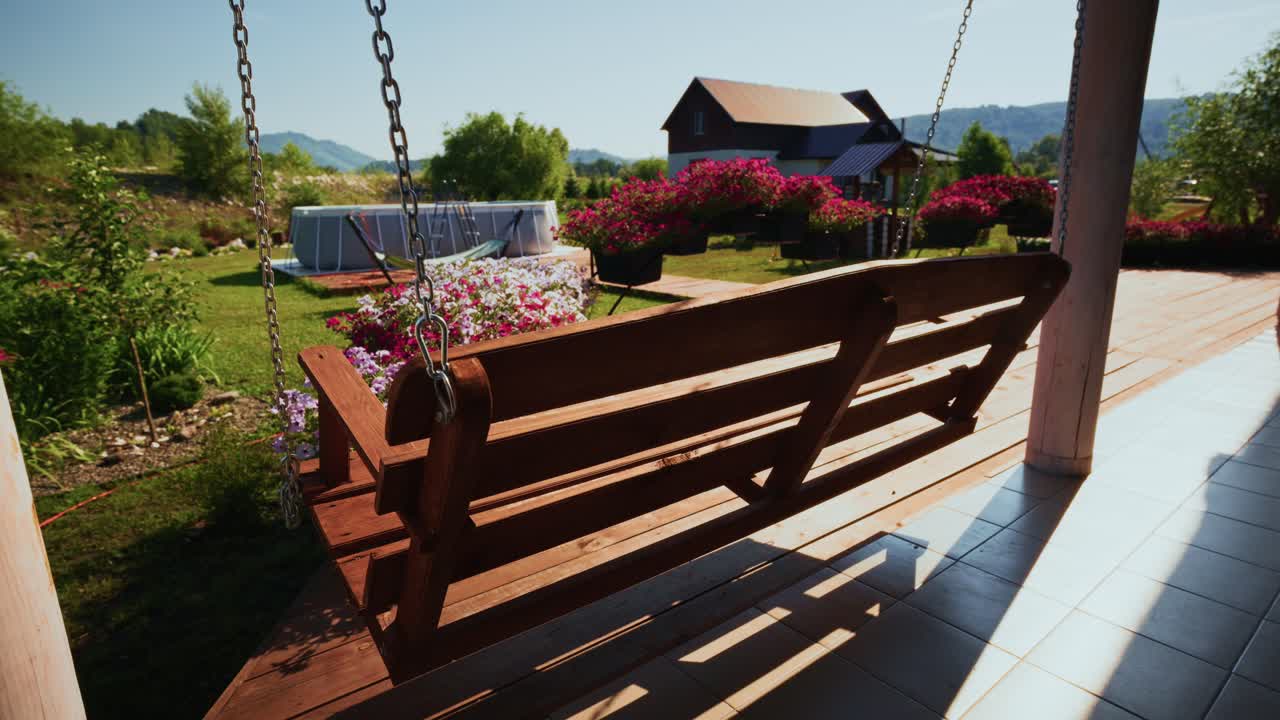 Wooden Porch Swing Swaying Gently in a Sunny Garden