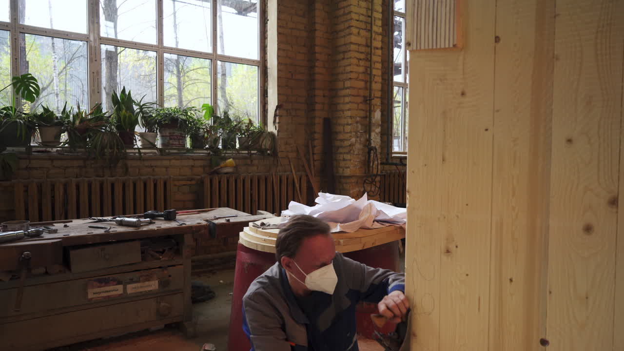 작업실 에서 나무 패널 을 작업 하는 목수