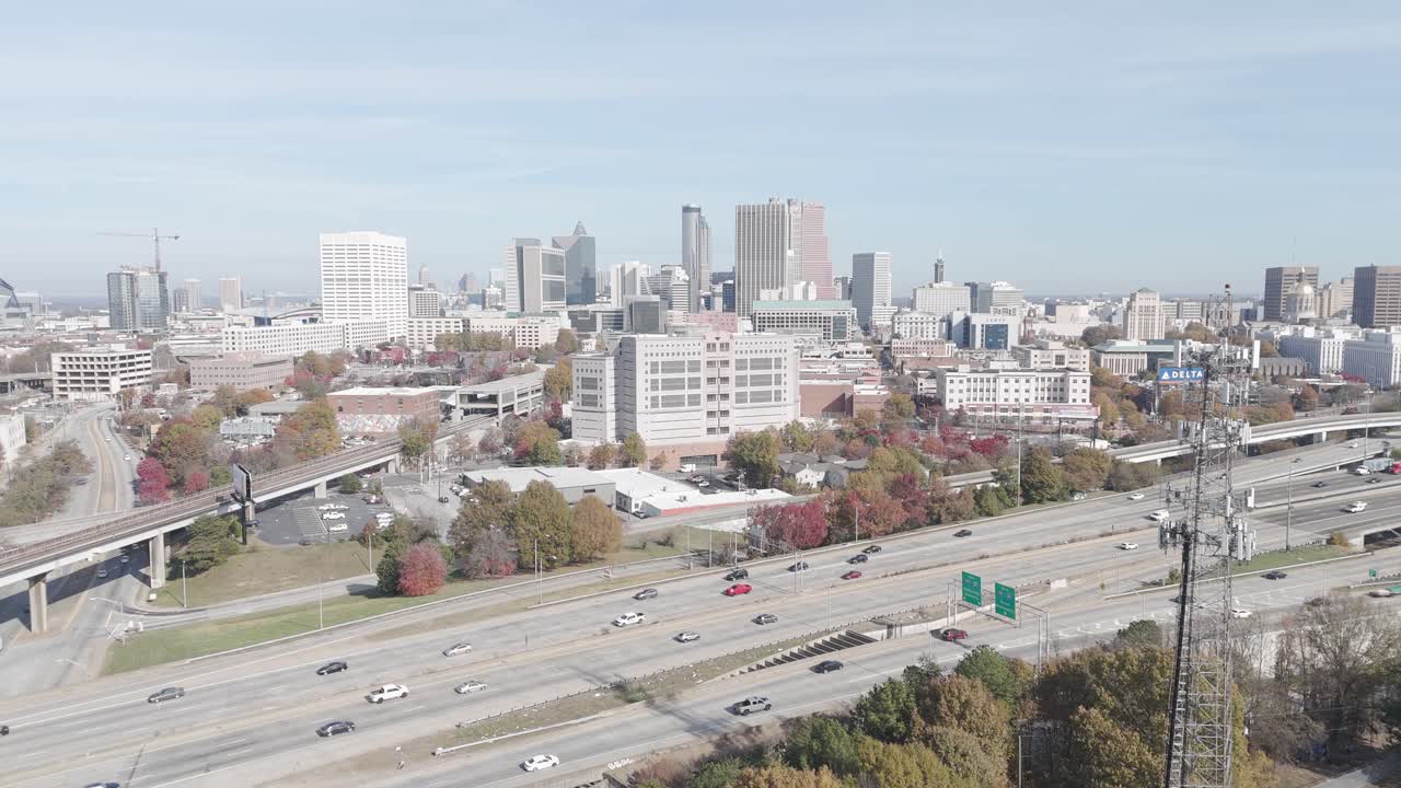High angle video of the city of Atlanta and the highway with car traffic under a clear blue sky
