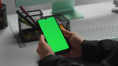 Hands-hold-green-smartphone-in-office-closeup.-Businessman-checking-messages