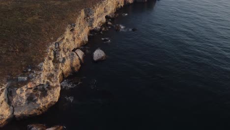 drone top down aerial view of waves splash against rocky seashore, background