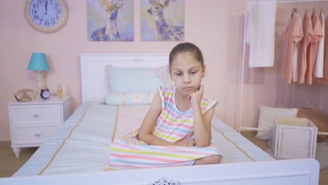 Thoughtful-girl-sitting-on-her-bed.