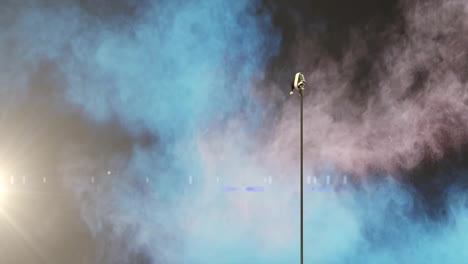 Animation-of-father-christmas-hat-on-retro-microphone-over-smoke-and-lights-on-dark-background