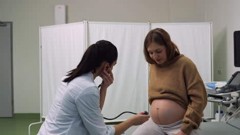 doctor checking pregnant woman's belly