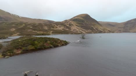 Loch-Skene-Ubicado-En-La-Parte-Superior-Del-Sendero-De-La-Yegua-Gris-Rodeado-De-Impresionantes-Vistas-A-La-Montaña