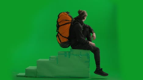 person sitting on steps with backpack