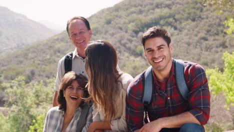 Couple-and-senior-parents-taking-a-break-on-a-mountain-walk