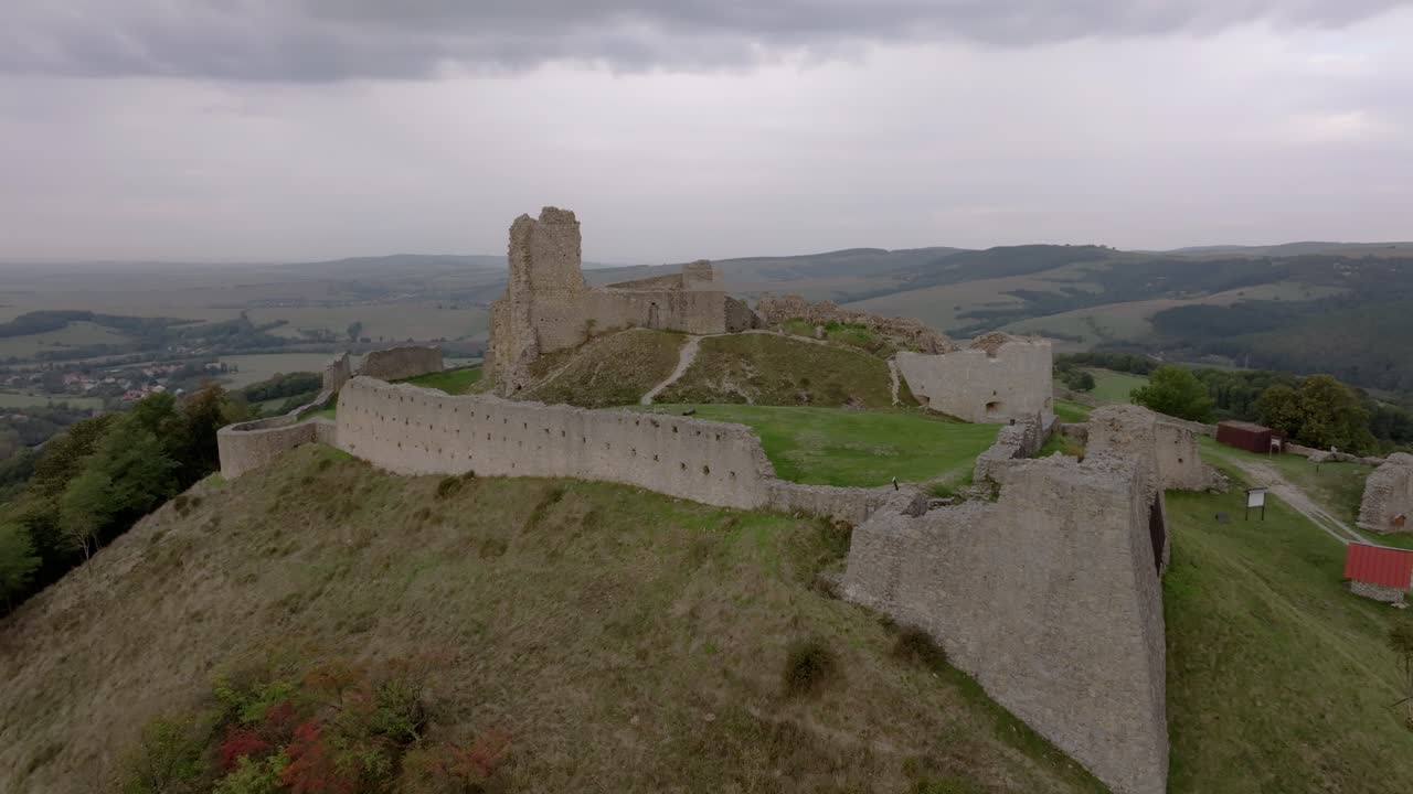 Drohnenansicht der Burg Branc, umgeben von Wildblumen und weiten Ebenen