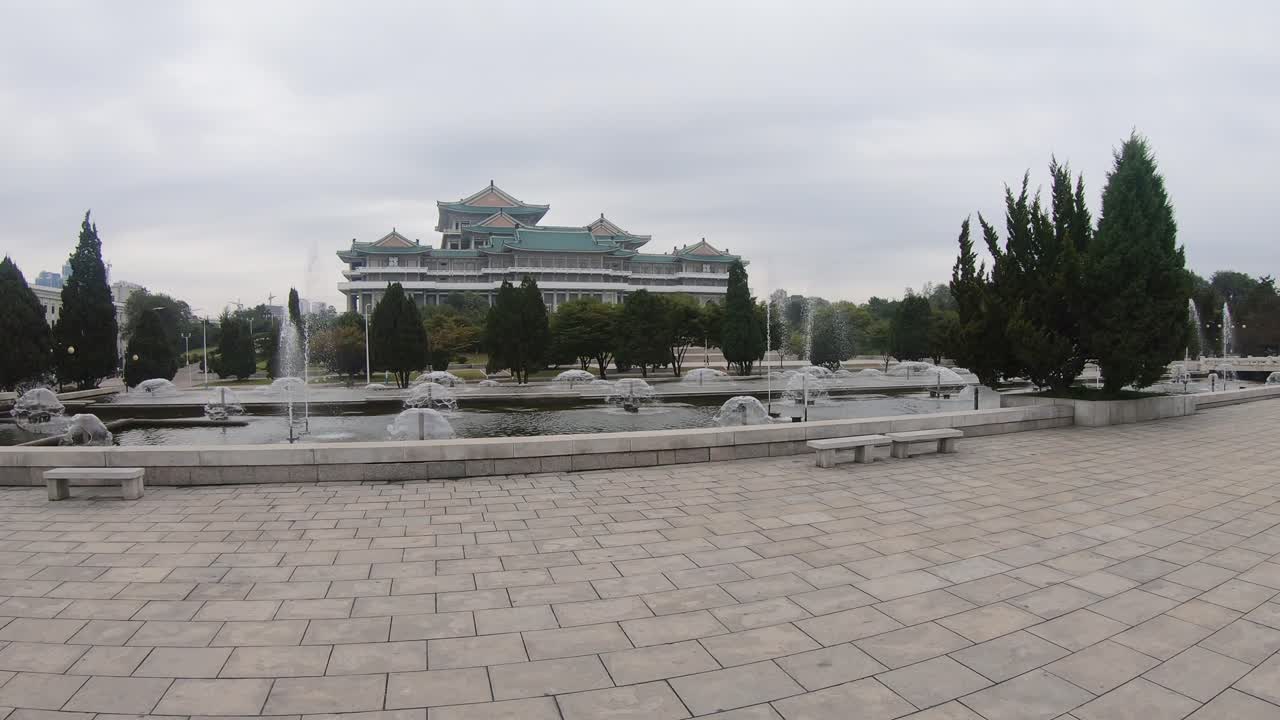Mansudae Fountain Park with Grand People's Study House in the background. Pyongyang, North Korea. Static Shot.