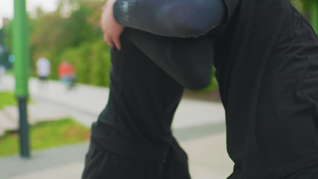 Park-Clinch-Verteidigungstraining, weiße Männer demonstrieren Handgelenk-Release-Choke-Escape, Nahbereichskontrolle, Ausbilder-Schüler-Rollen, schwarze Kleidung, städtisches Grün, Hände greifen Kragen, taktische Bewegung